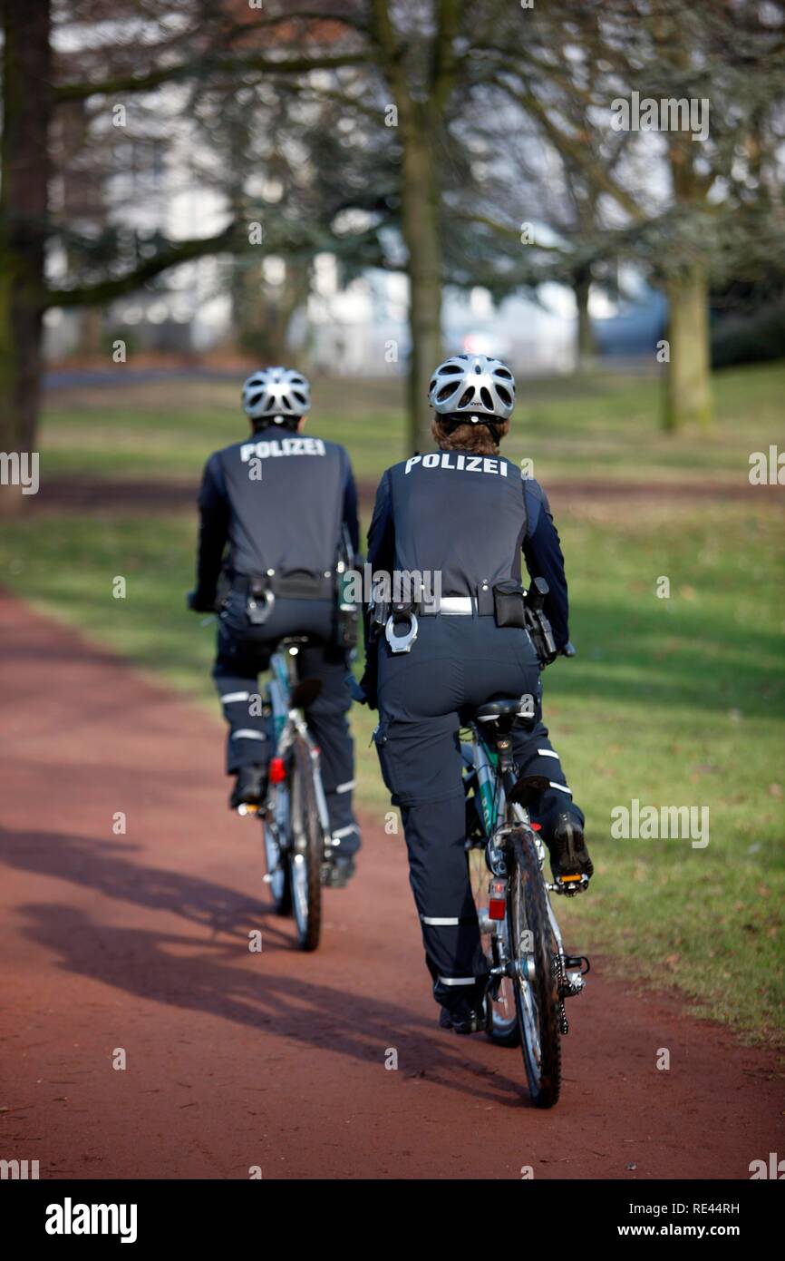Bike police patrolling in a municipal park Stock Photo