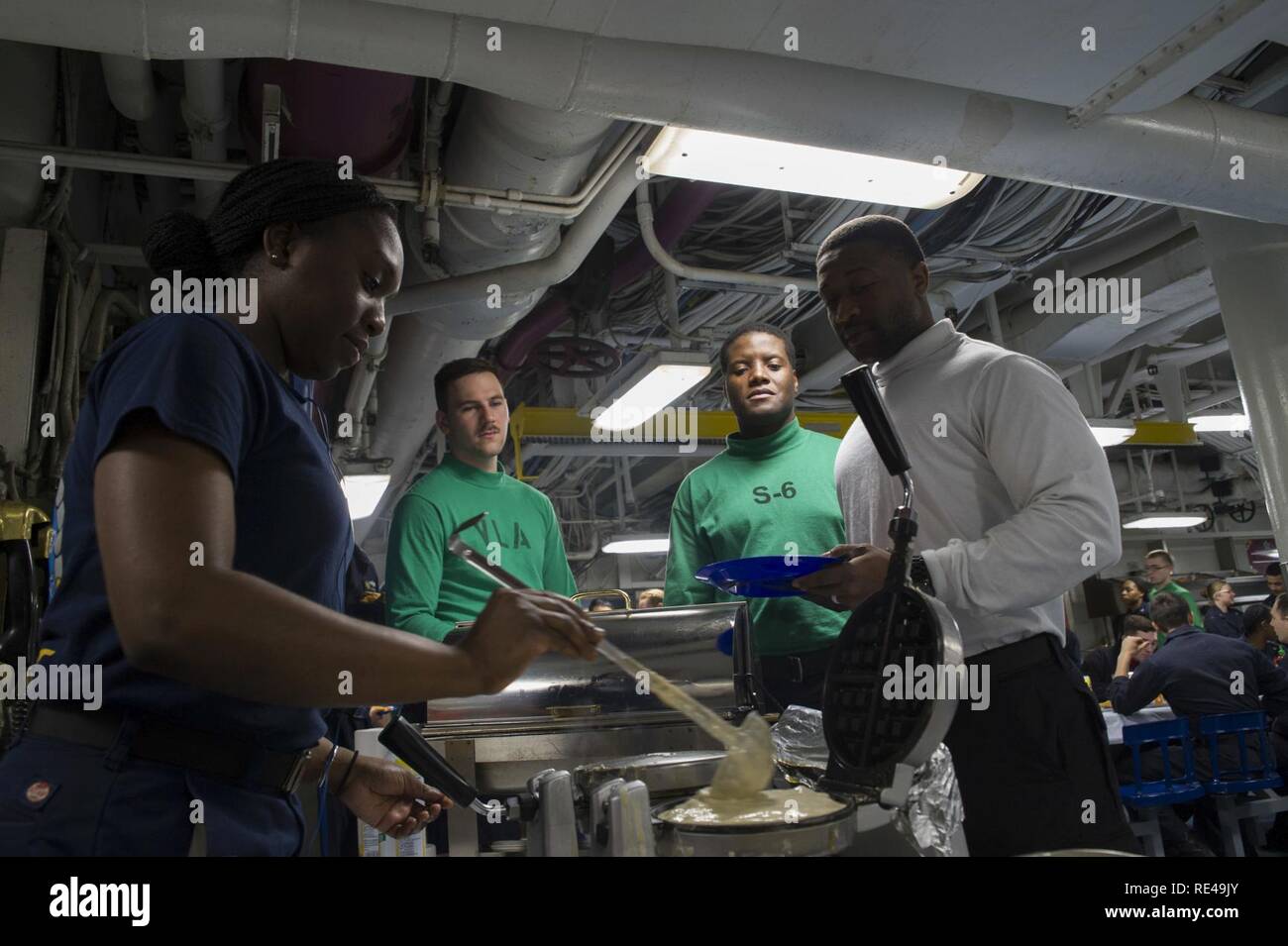 U.S. 5TH FLEET AREA OF OPERATIONS (Nov. 27, 2016) Petty Officer 3rd Class Detra Penn, from Saint Thomas, U.S. Virgin Islands, serves waffles to Sailors on the mess decks of the aircraft carrier USS Dwight D. Eisenhower (CVN 69) (Ike) during Sunday brunch. Ike and its carrier strike group are deployed in support of Operation Inherent Resolve, maritime security operations and theater security cooperation efforts in the U.S. 5th Fleet area of operations. Stock Photo