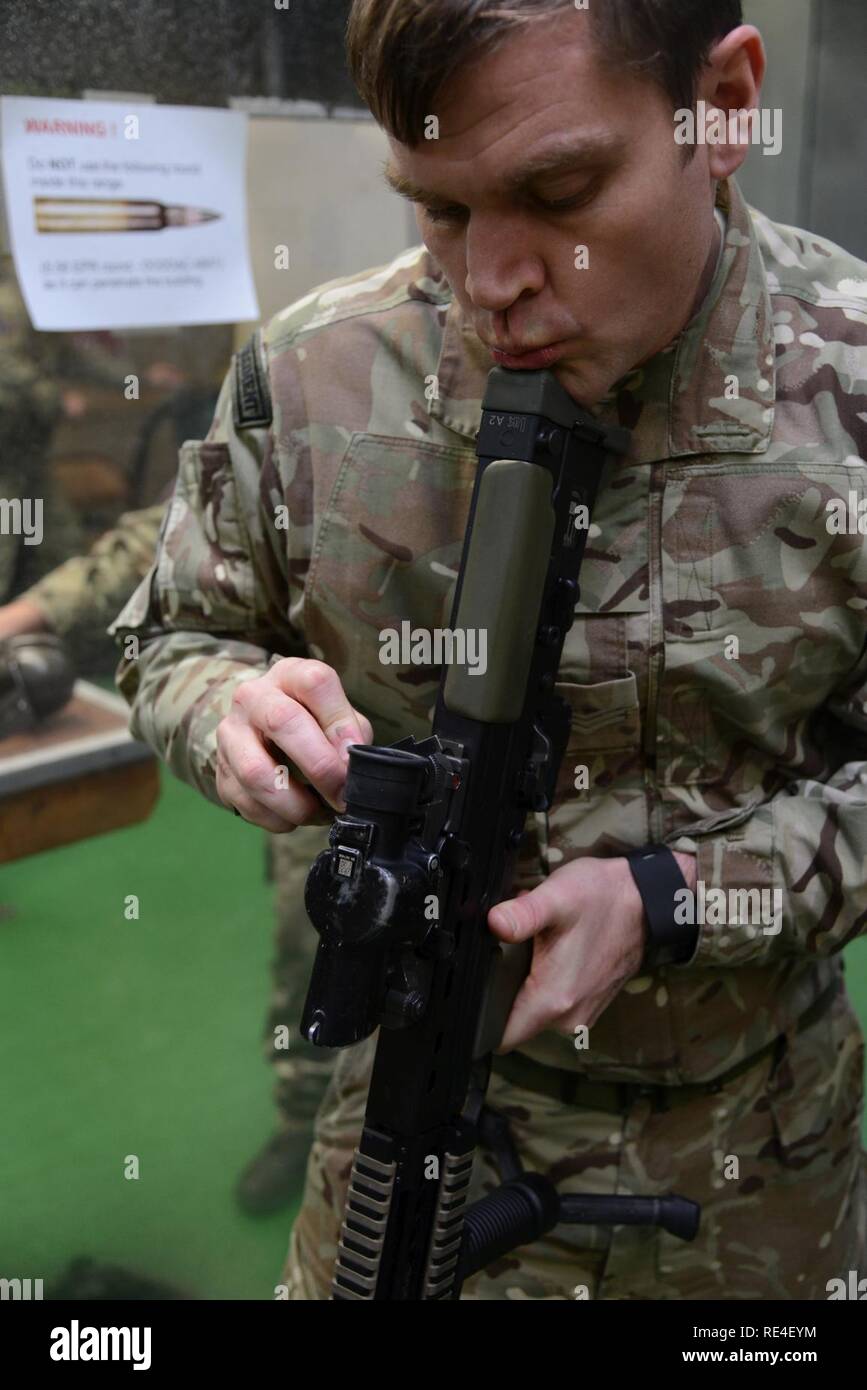 Royal Air Forces Member (instructor) of the Joint European Training Team, zeroes British soldier's weapon assigned to local units during the L85 A2 rifle calibration at the Training Support Center Benelux 25 meter indoor range, in Chièvres Air Base, Belgium, Nov. 30, 2016. British Forces Trained under supervision of the British Joint European Training Team Stock Photo