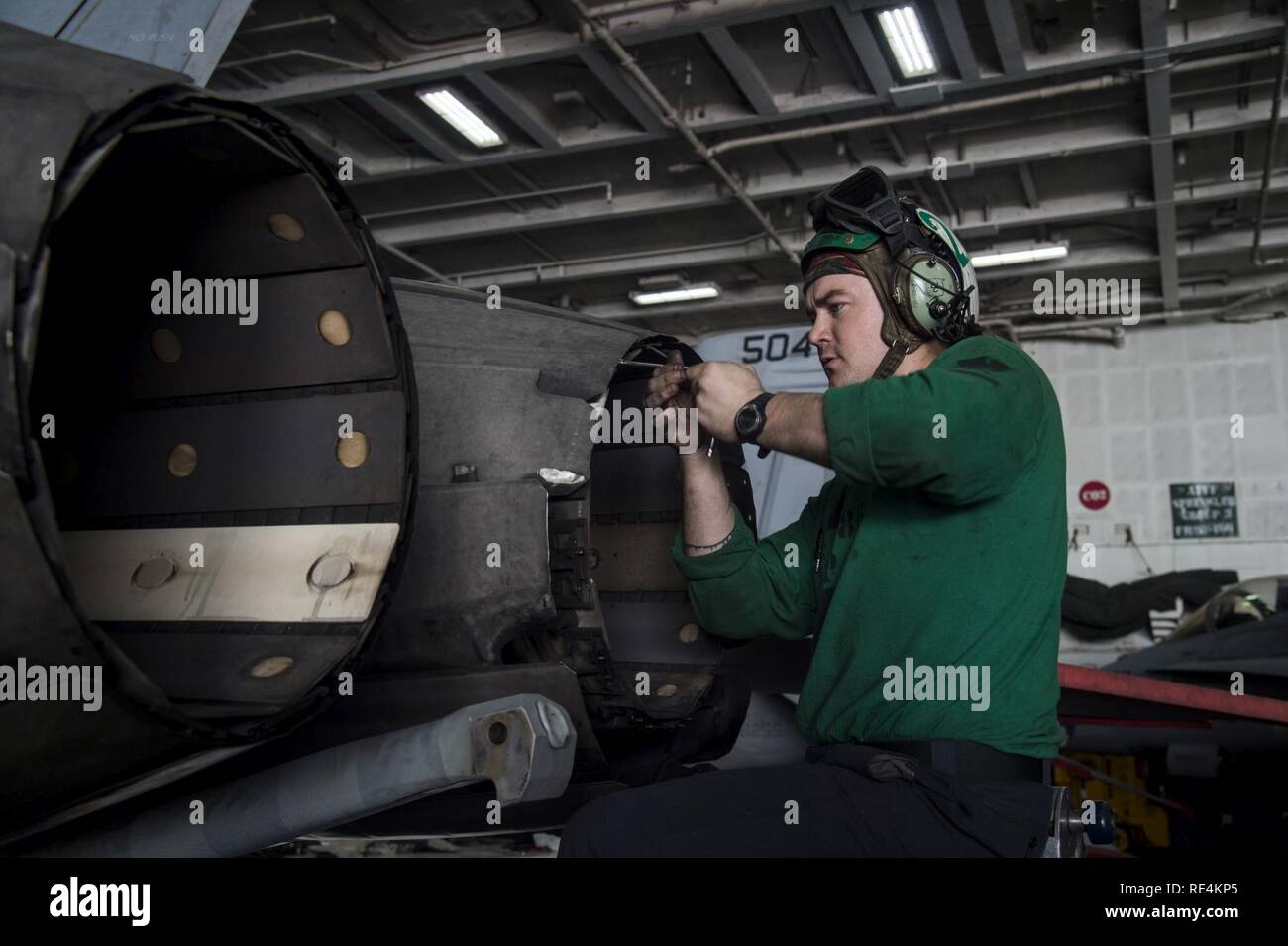 ARABIAN GULF (Nov. 25, 2016) Petty Officer 3rd Class Jacob Wiggs, from Roswell, N.M. inspects the variable exhaust nozzle for a 200-hour flight engine inspection in the hangar bay of the aircraft carrier USS Dwight D. Eisenhower (CVN 69) (Ike). Ike and its Carrier Strike Group are deployed in support of Operation Inherent Resolve, maritime security operations and theater security cooperation efforts in the U.S. 5th Fleet area of operations. Stock Photo