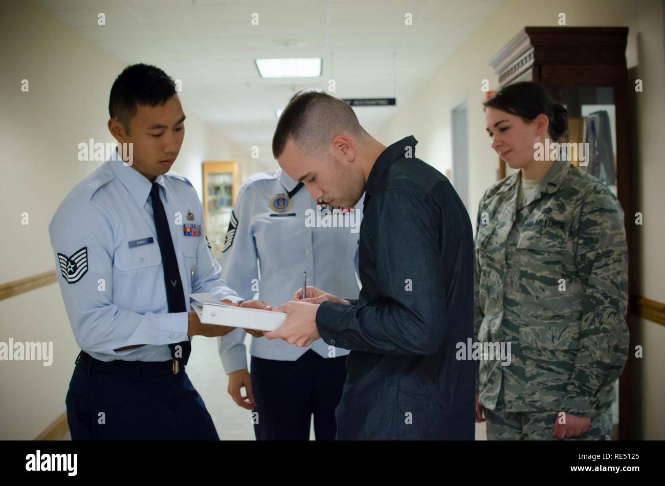 Tech. Sgt. Badin Burch, 403rd Wing recruiter, helps Senior Airman Brian