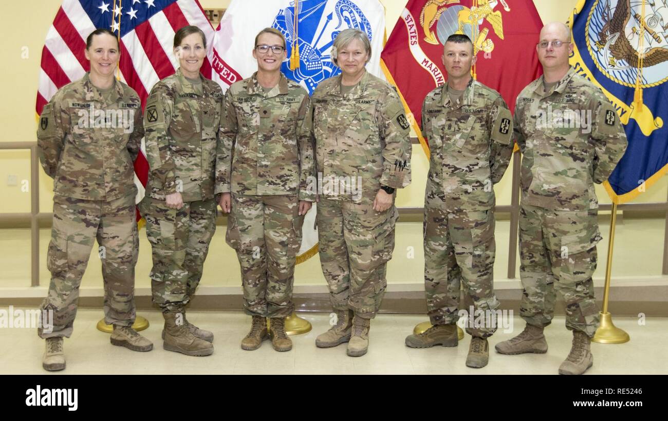 U.S. Army Spc. Jenna Van Horn, a newly promoted pharmacy specialist, assigned to the 452nd Combat Support Hospital poses for a photo with her unit leadership after her promotion ceremony in Camp Arifjan, Kuwait, Jan. 2, 2019. Promotion ceremonies like this further enhance and prepare capable leaders in the Army. Stock Photo