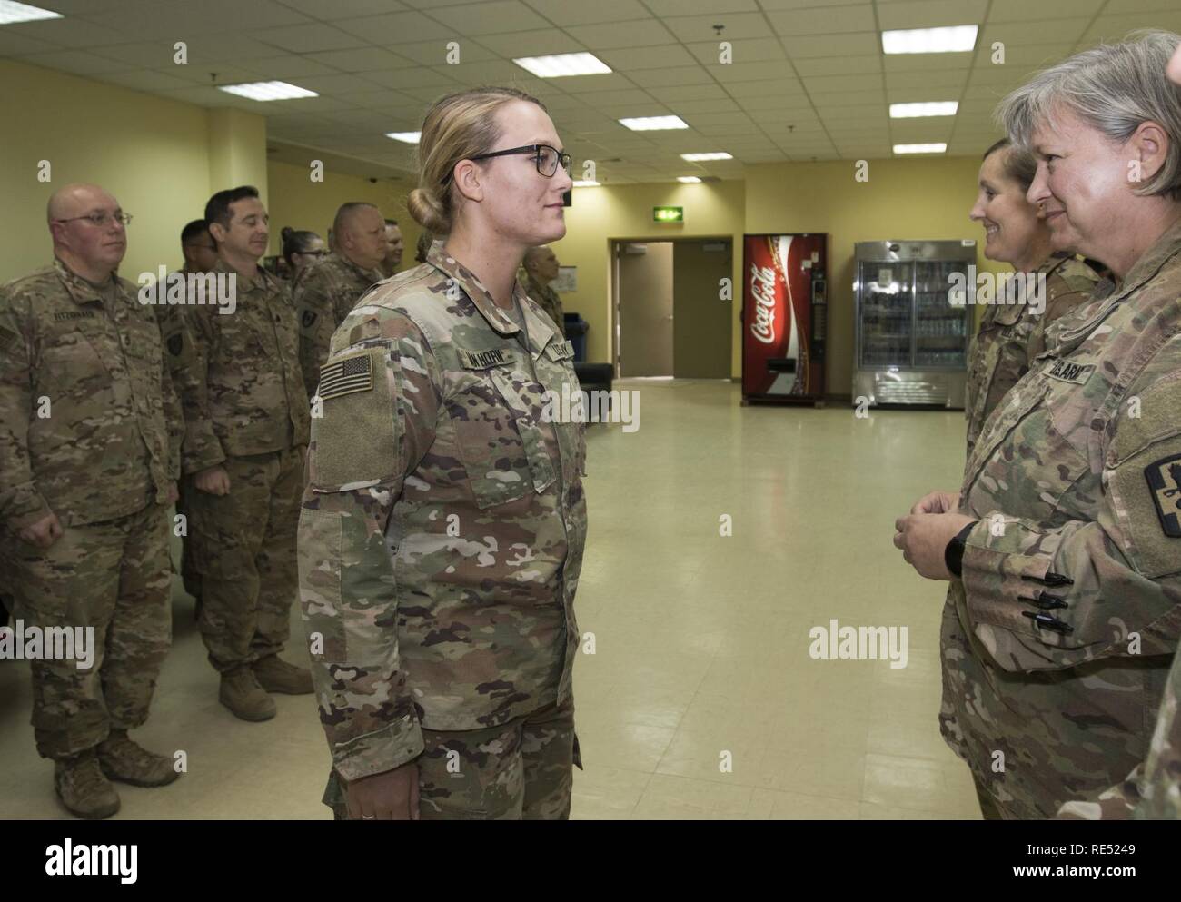 U.S. Army Pfc. Jenna Van Horn, a pharmacy specialist, is called to the front of the formation by her mother, U.S. Army Maj. Lisa Van Horn, the chief of patient administration, both assigned to the 452nd Combat Support Hospital during Jenna Van Horn's promotion ceremony in Camp Arifjan, Kuwait, Jan. 2, 2019. The Van Horns shared the unique experience of deploying together as a mother and daughter team to help support the health readiness of service members throughout Central Command's area of responsibility. Stock Photo