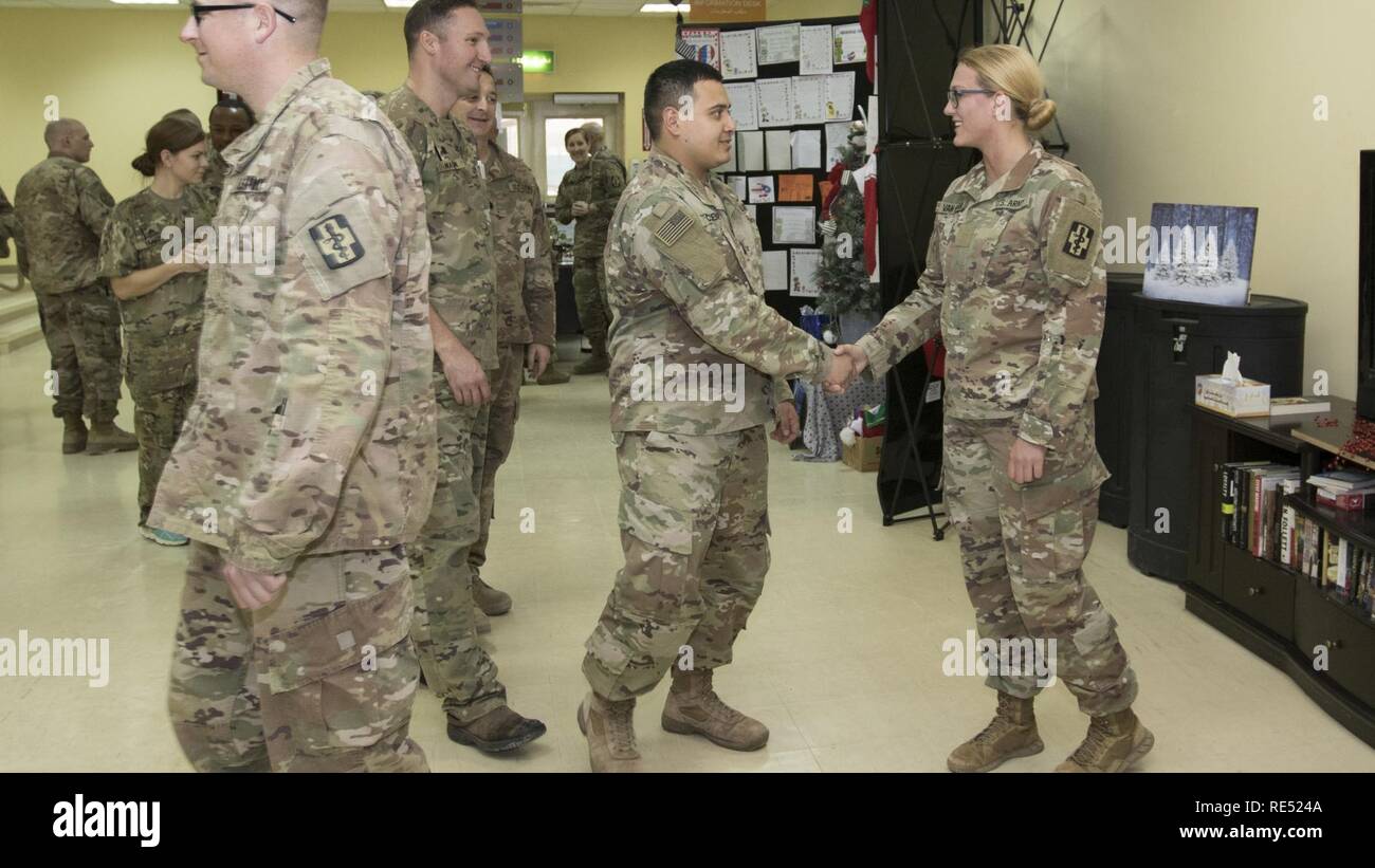 U.S. Army Spc. Jenna Van Horn, a newly promoted pharmacy specialist, assigned to the 452nd Combat Support Hospital, is congratulated by her unit members after her promotion ceremony in Camp Arifjan, Kuwait, Jan. 2, 2019. Promotion ceremonies like this further enhance and prepare capable leaders in the Army. Stock Photo