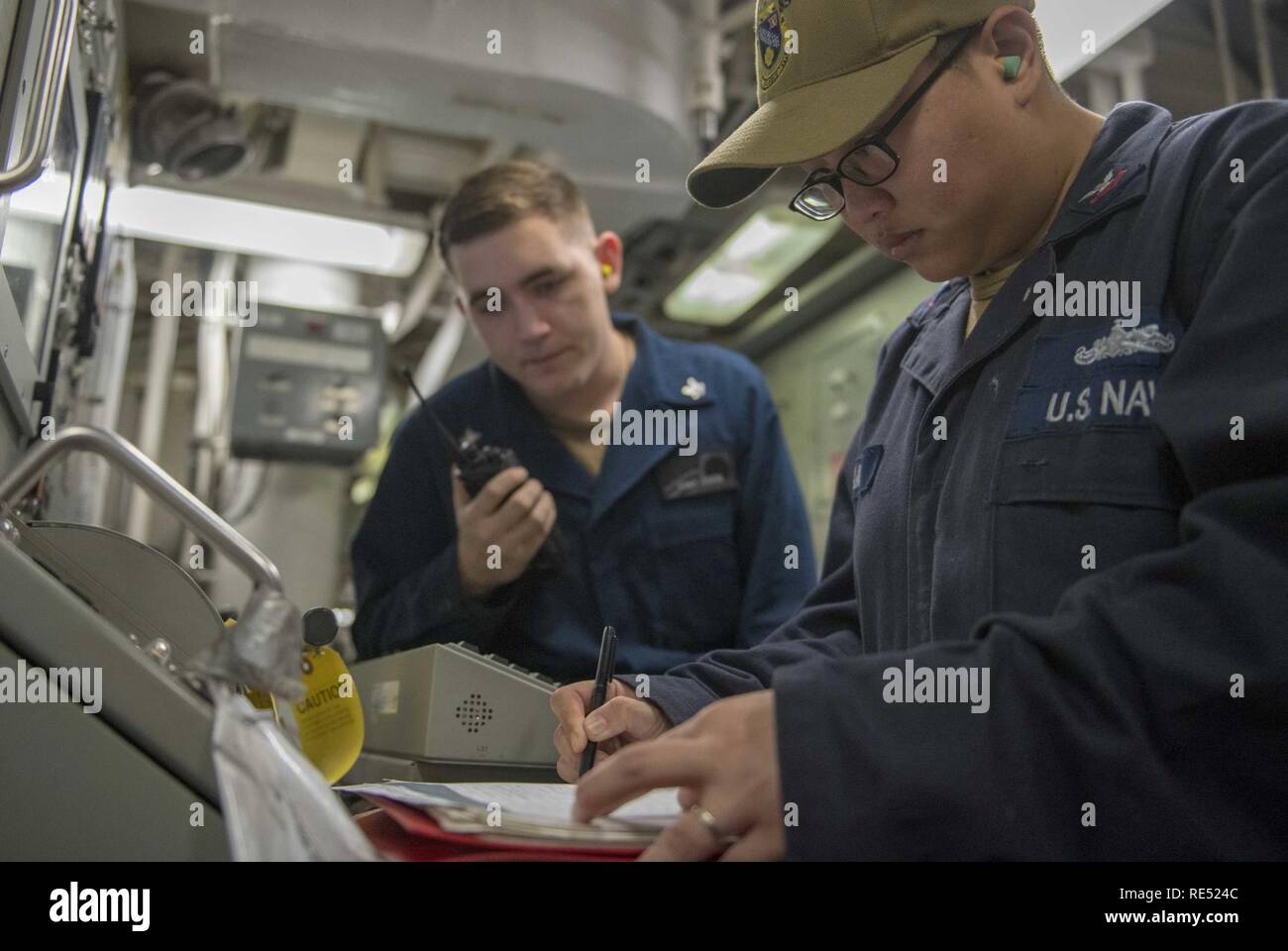 EAST CHINA SEA (Jan. 1, 2018) Gas Turbine Systems Technician (Electrical) 1st Class Cleo Vidamo, from Lisle, Ill., right, and Gas Turbine Systems Technician (Mechanical) 3rd Class Christopher Garza, from Arlington, Texas, verify a gas turbine system’s parameters aboard the Arleigh Burke-class guided-missile destroyer USS McCampbell (DDG 85). McCampbell is forward-deployed to the U.S. 7th Fleet area of operations in support of security and stability in the Indo-Pacific region. Stock Photo