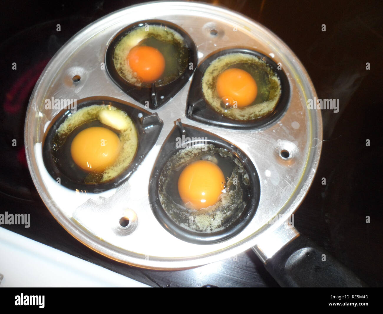https://c8.alamy.com/comp/RE5M4D/poaching-eggs-in-a-mass-produced-egg-poaching-pan-RE5M4D.jpg