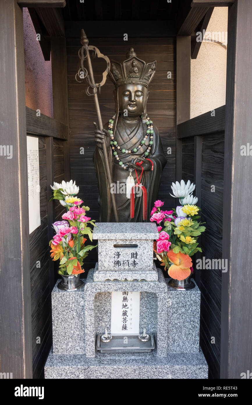 Kumamoto, Japan - November 13, 2018: Buddhist shrine with buddha statue with crown and pilgrims staff as a symbol for power Stock Photo
