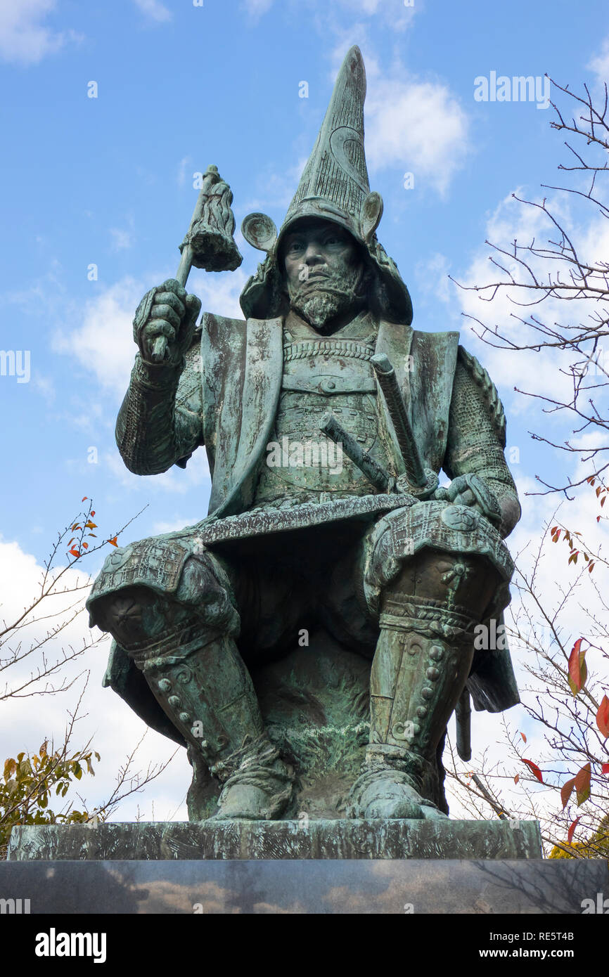 Kumamoto, Japan - November 14, 2018: Bronze statue of Kato Kiyomasu seated in front of his Kumamoto Castle and dressed in kacchu battle armour and nag Stock Photo