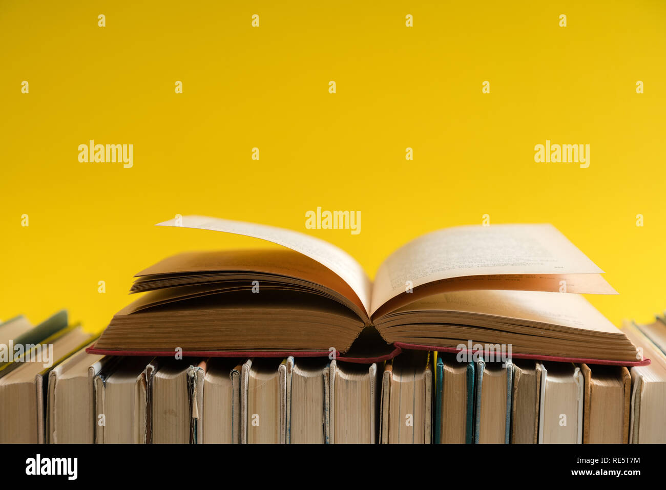 Open book on yellow background, hardback books on wooden table. Education  and learning background. Back to school, studying. Copy space for text  Stock Photo - Alamy