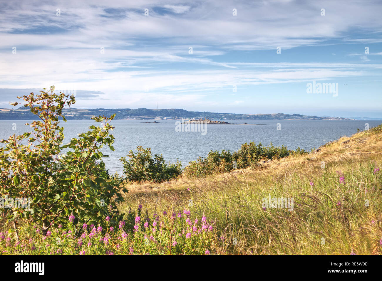 A photograph of the island of Inchmickery in the Firth of Forth, taken from Cramond Island near Edinburgh, Scotland, United Kingdom. Stock Photo