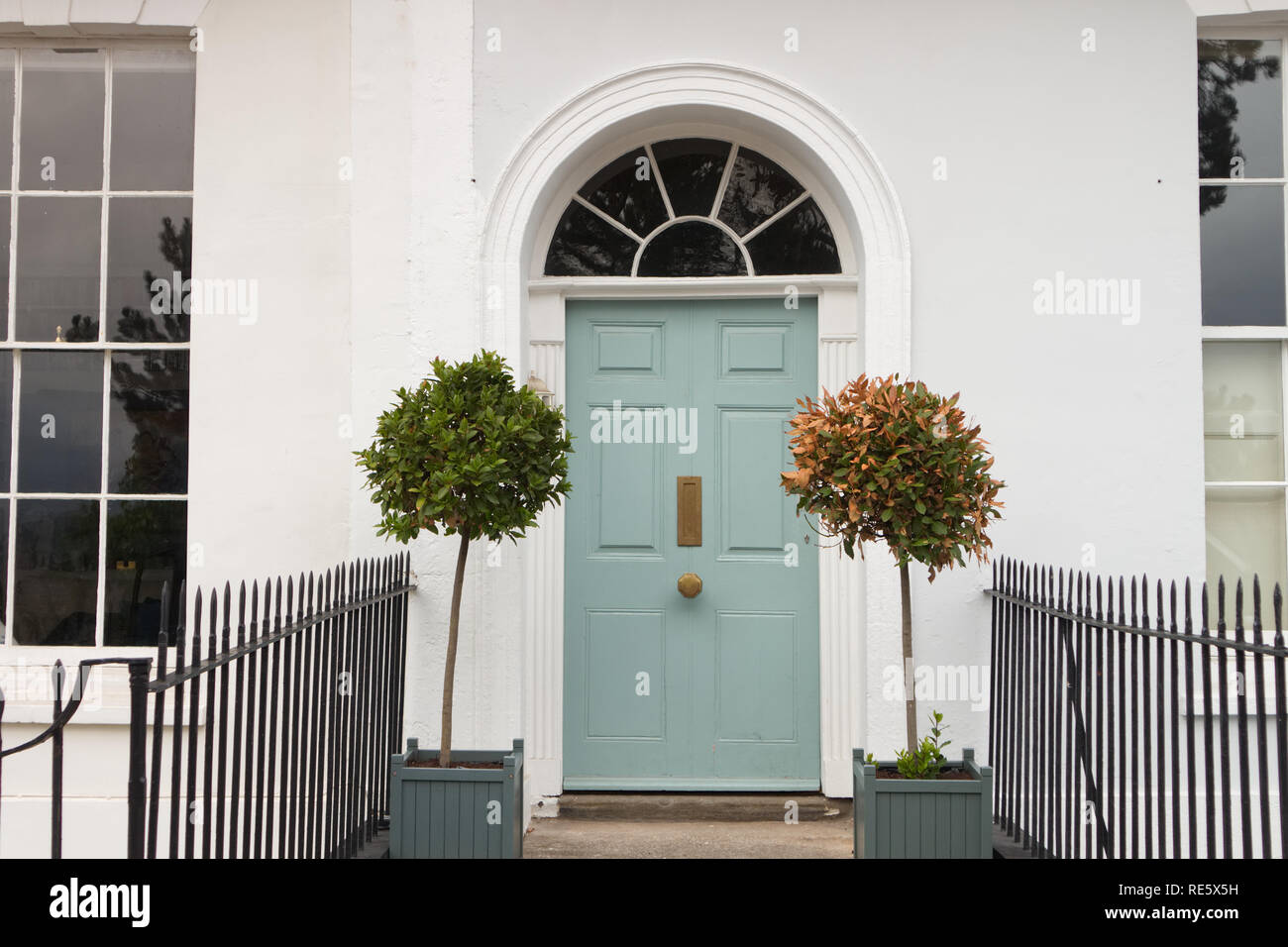 A beautiful old door from a Georgian Architecture building with a vertical letterbox and metal fence Stock Photo