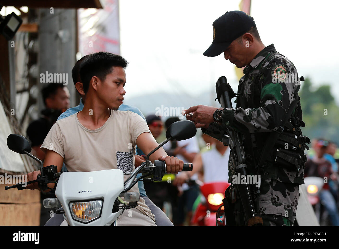 Cotabato City, Philippines. 20th Jan, 2019. A policeman from the Philippine National Police inspects the identification cards of motorists during a security check at a road in Cotabato City, the Philippines, Jan. 20, 2019. Muslim Filipinos will cast their vote on Monday to ratify the landmark Bangsamoro Organic Law (BOL), a law that will pave the way for wider self-rule to the Muslim minority in the Philippines and is hoped to end the decades-old conflict in southern Philippines. Credit: Rouelle Umali/Xinhua/Alamy Live News Stock Photo