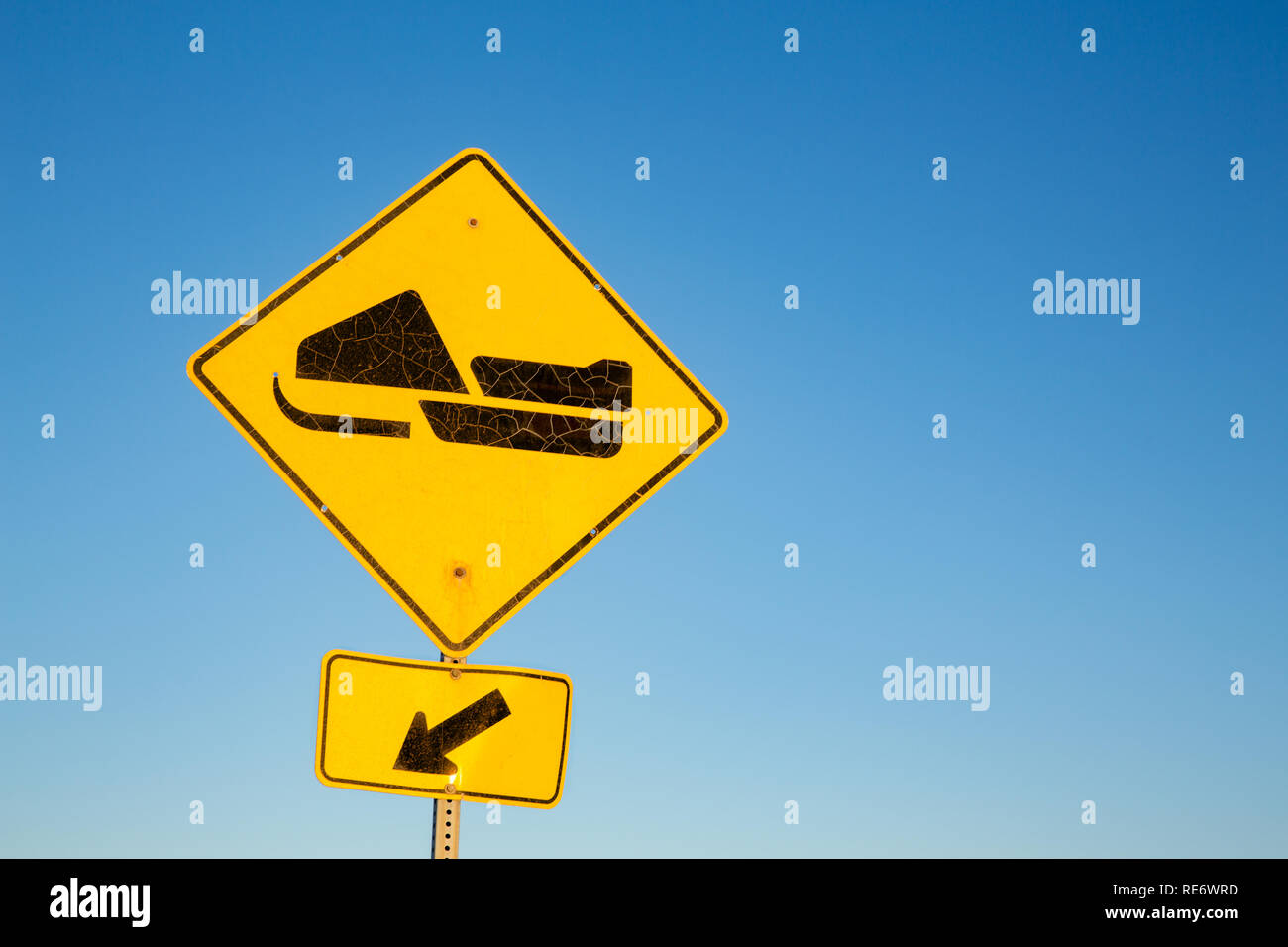 Yellow road sign for Skidoo or Snowmobile trail, with blue sky background and space for text. Quebec Province, Canada. Stock Photo