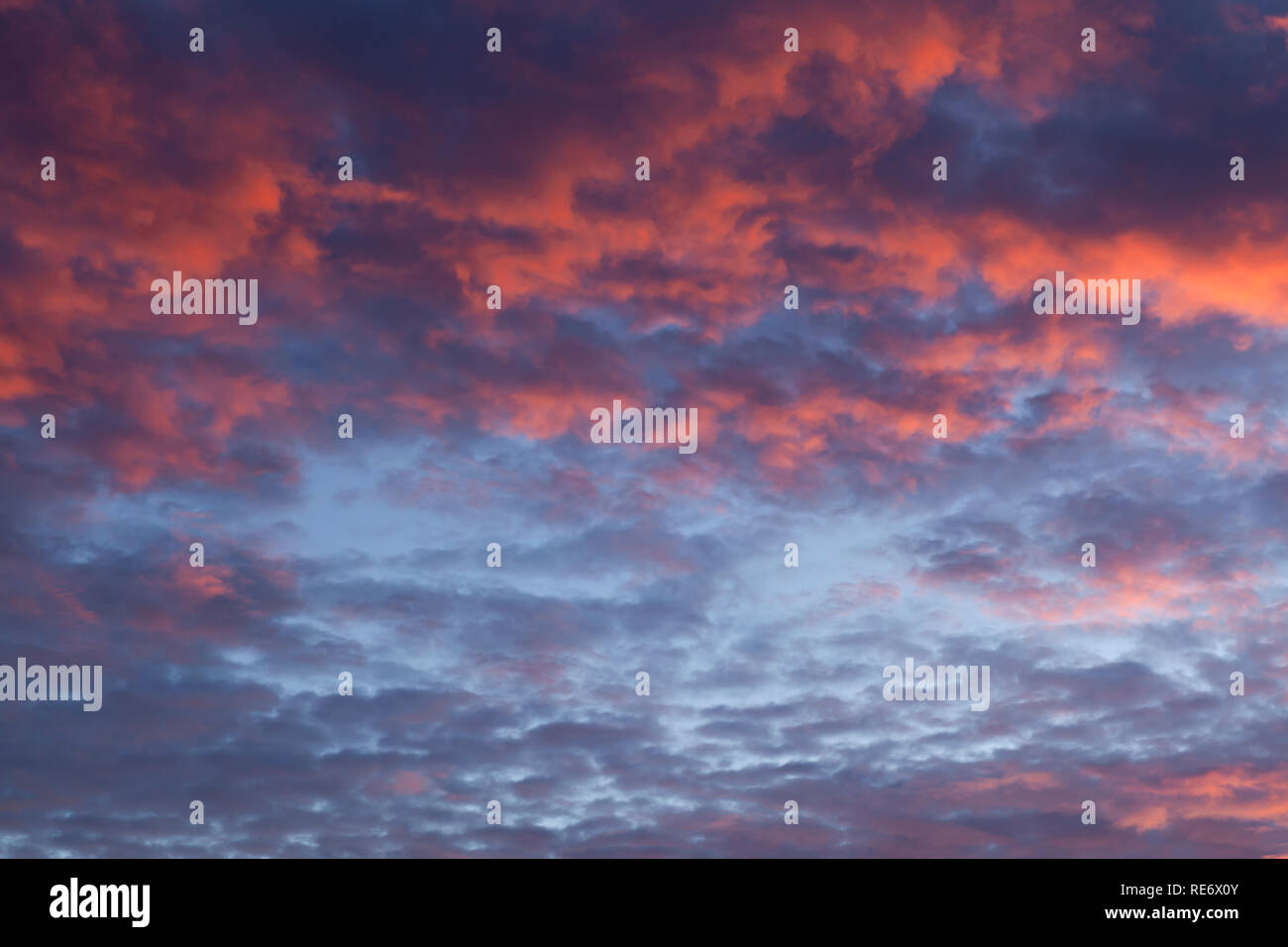 Dramatic pink sunset cloudscape with a little blue sky poking through Stock Photo