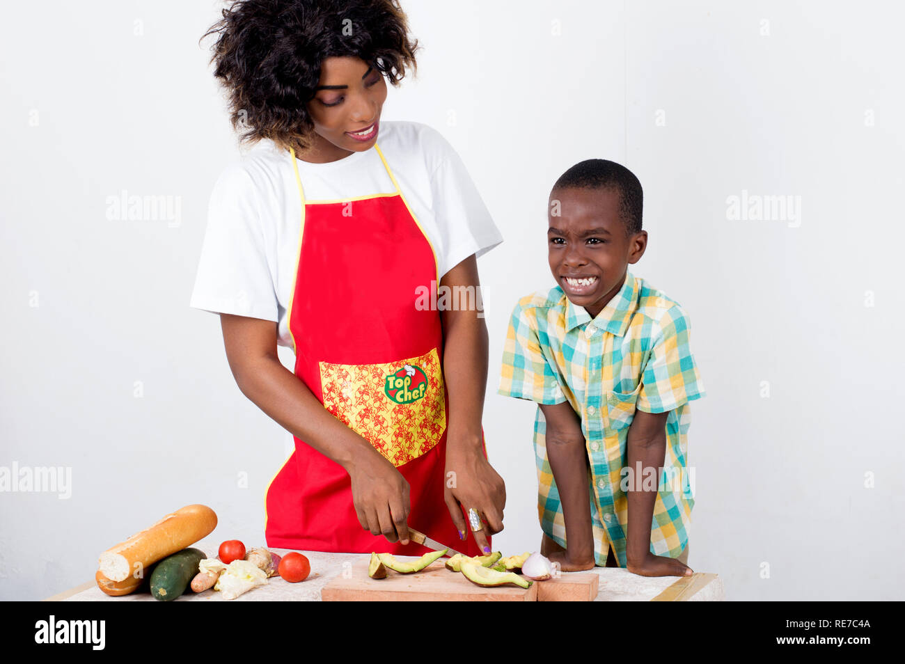 Young woman explaining to her child how to make a meal of vegetables