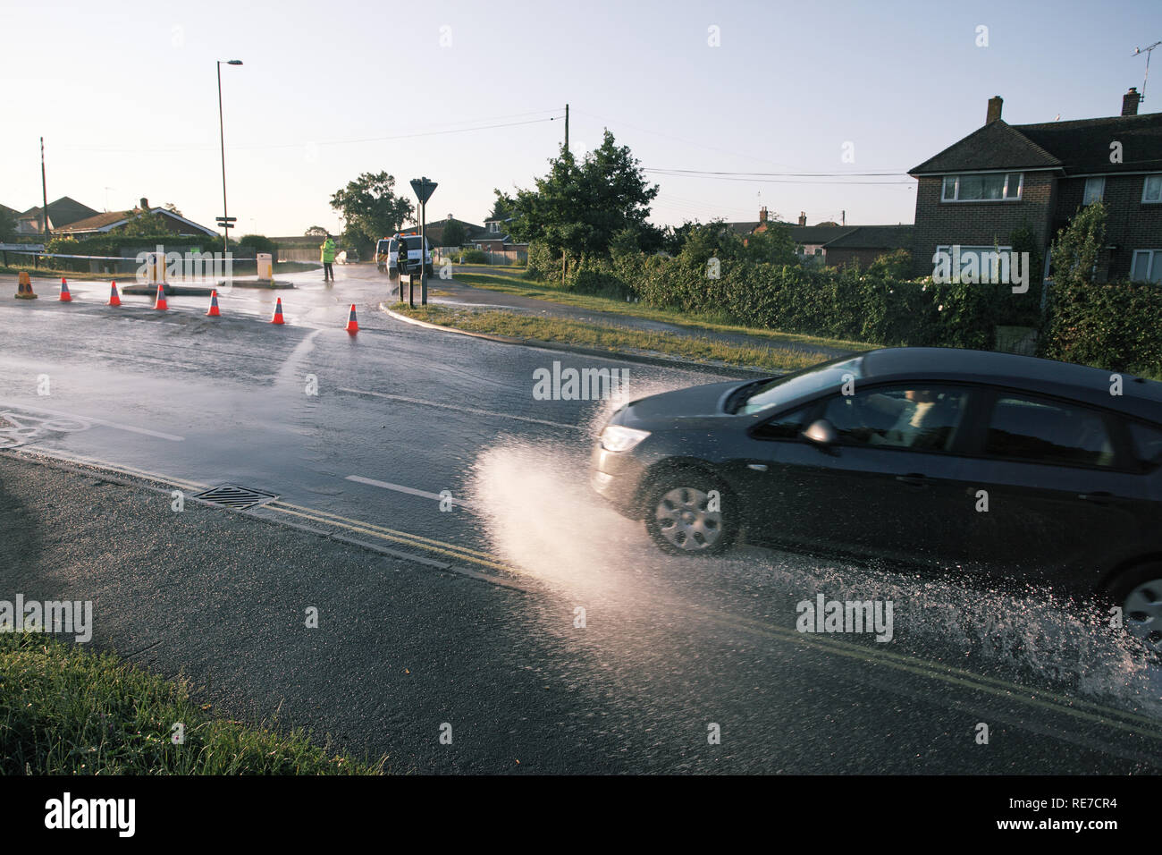 Flooded road due to burst water main Ringwood Hampshire England UK Stock Photo