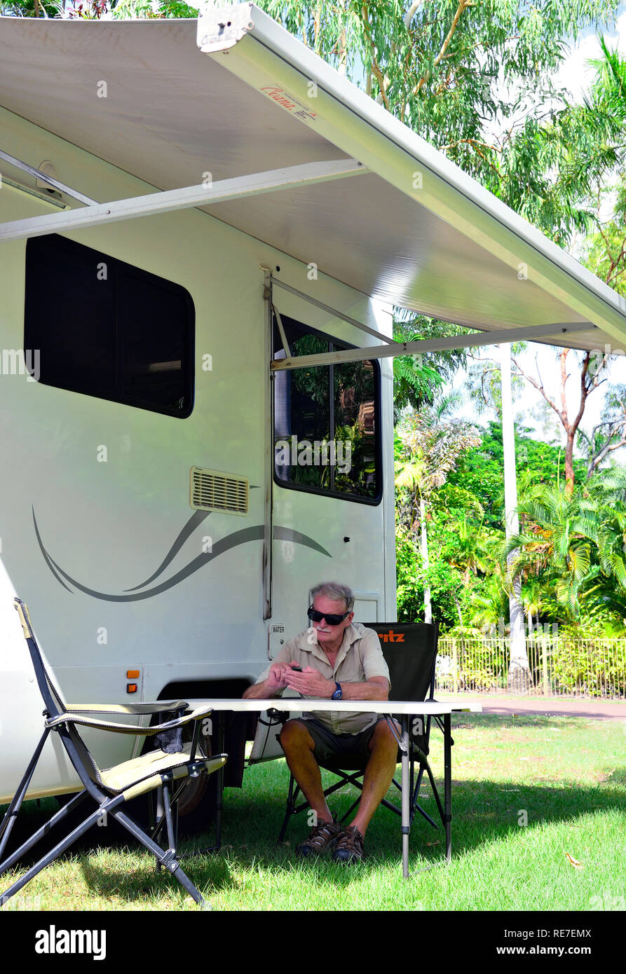 Tourist sitting under motorhome awning at the Batchelor Holiday Park, Rum Jungle Road,Batchelor, Litchfield, Northern Territory,  Australia Stock Photo