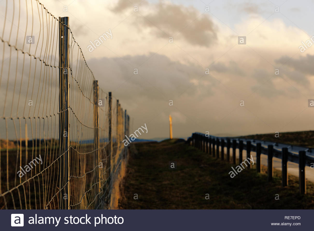Evening light on a fence between road and railway line in Bavaria, Germany Stock Photo