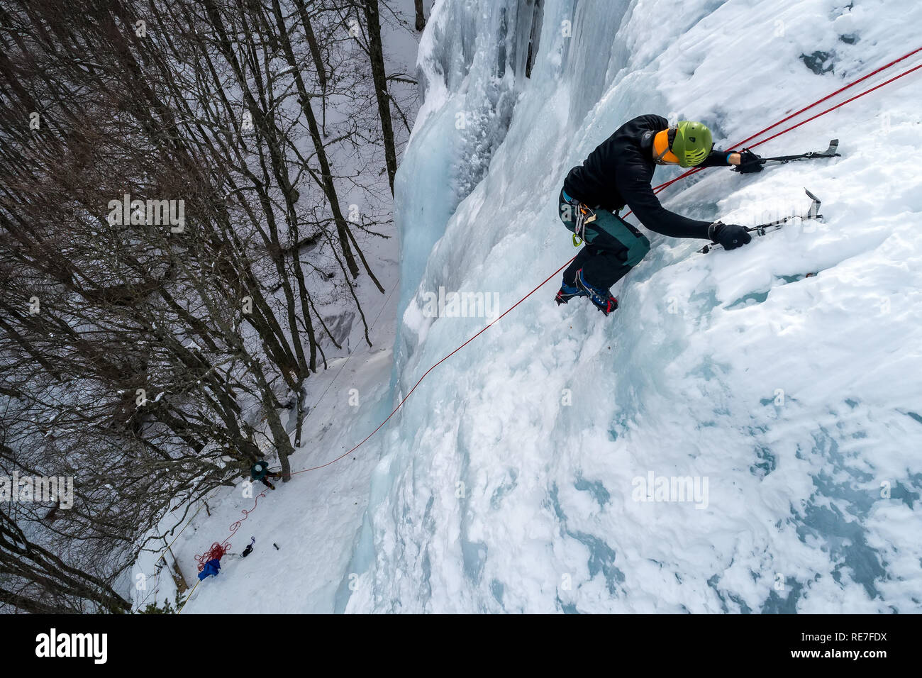 Ice climbing the North Greece, man climbing frozen waterfall. Stock Photo