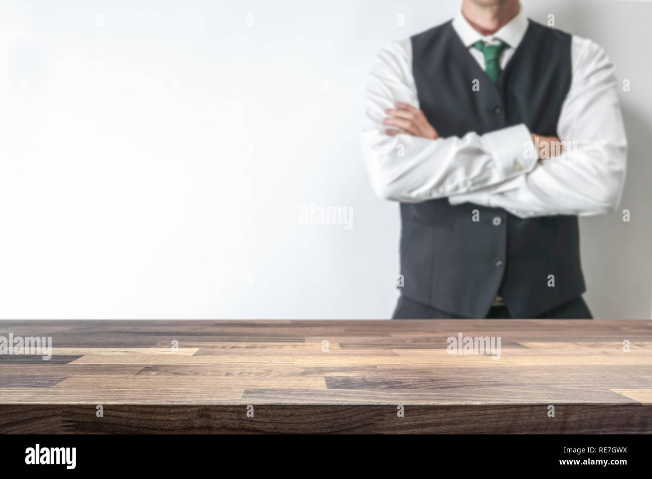 Empty table top for product display montage. Office work space concept. Big boss businessman blurred in the background. Stock Photo