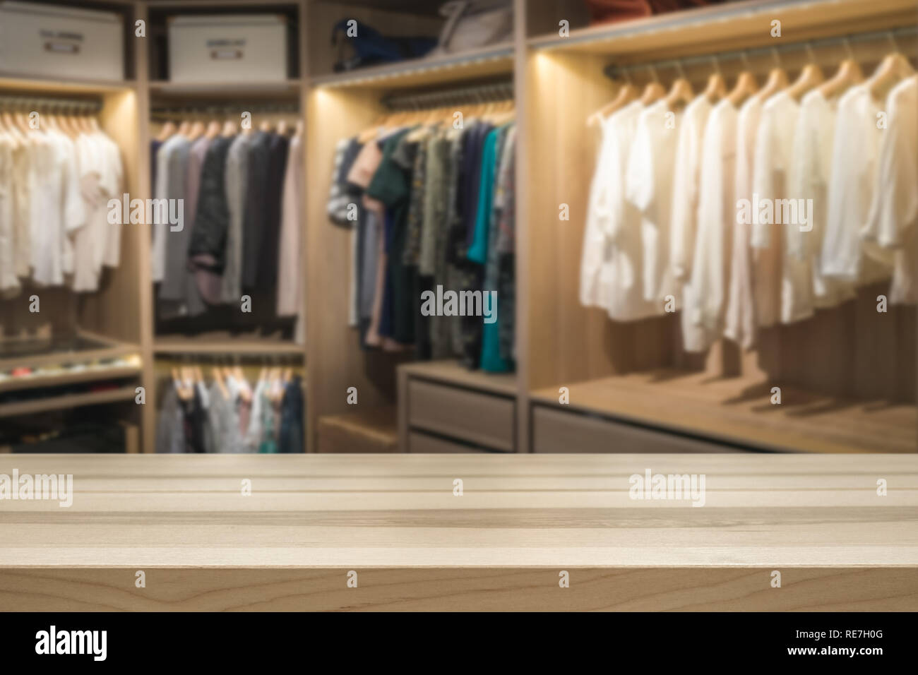 Empty table top for product display montage. Fashion and clothes concept. Walk in closet wardrobe blurred in the background. Stock Photo