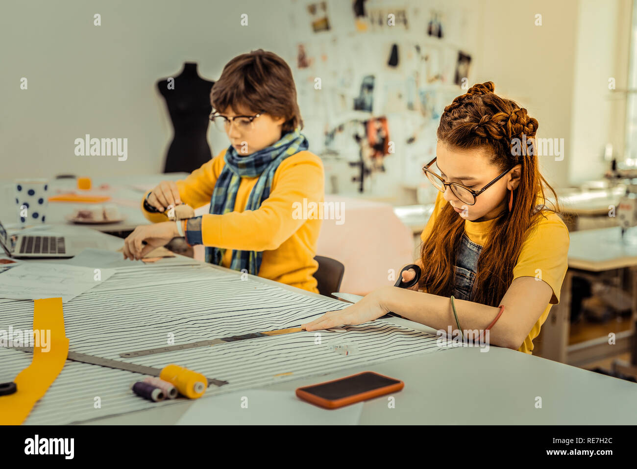 Children of fashion designer drafting patterns for their mother Stock Photo