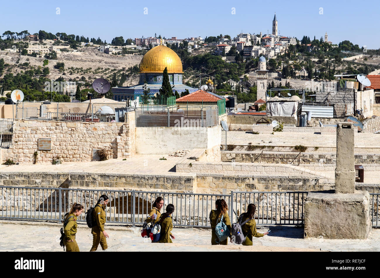 IDF (Israel Defense Forces) young female trainees in military outfit walking on the rooftops of Jerusalem, with Temple Mount in the background Stock Photo