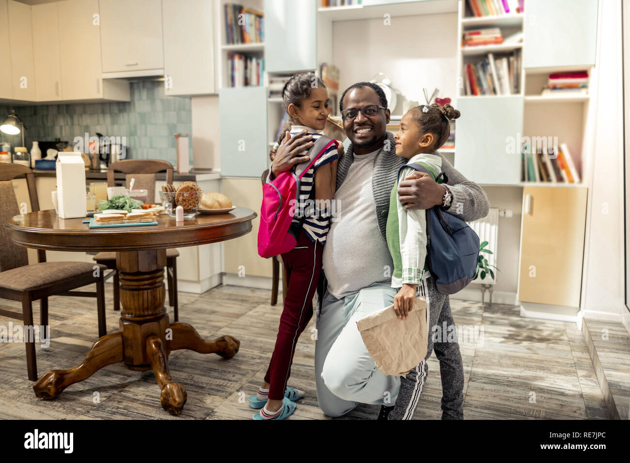 Father feeling happy after family breakfast together with daughters Stock Photo