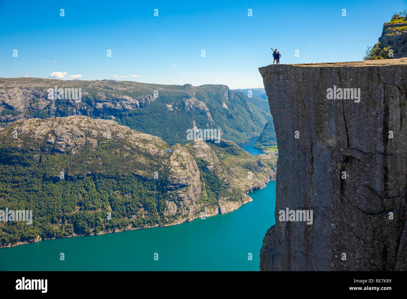 Hiker standing on Preikestolen and looking on the fjerd, Preikestolen - famous cliff at the Norwegian mountains Stock Photo