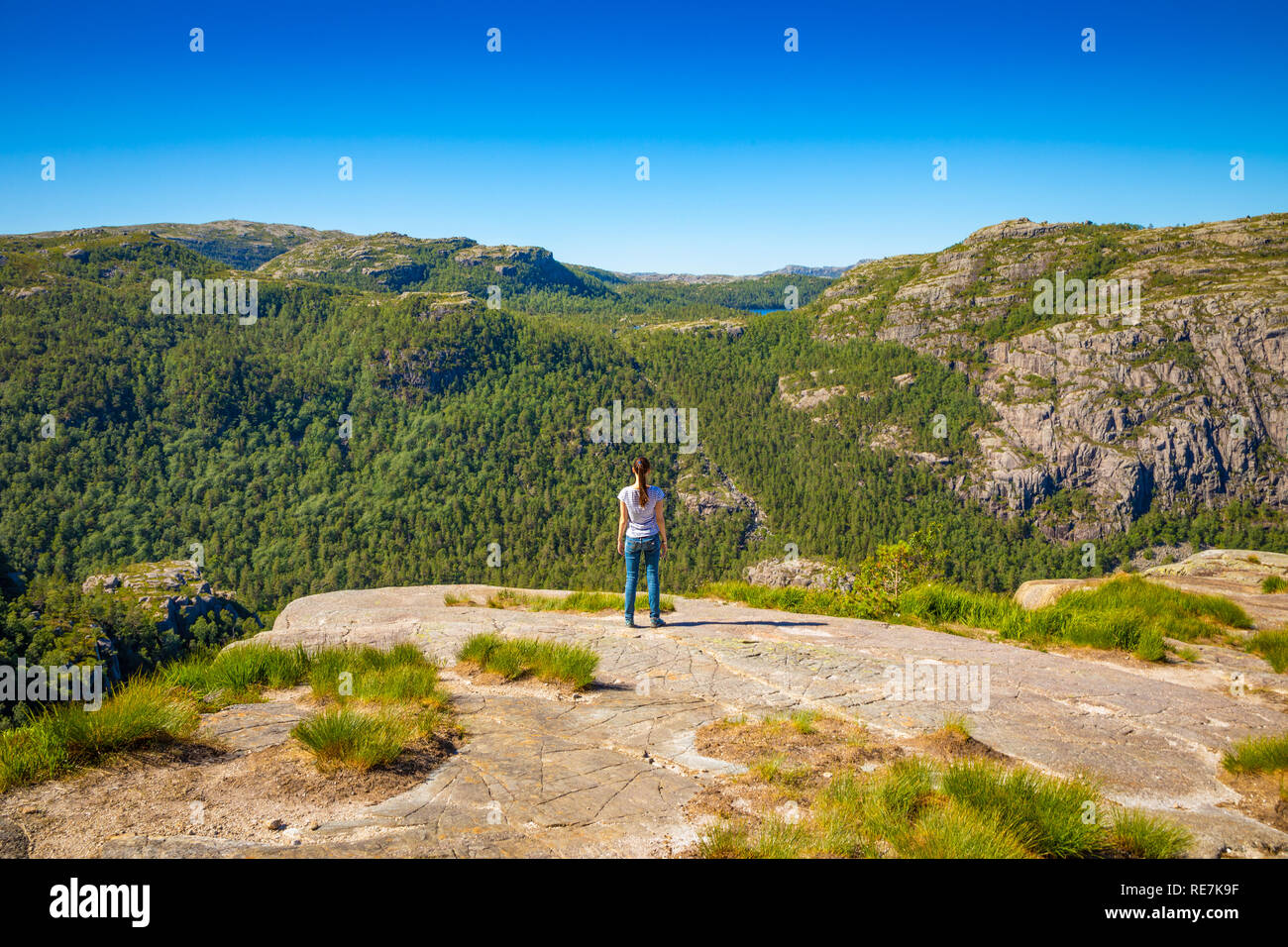 Hiker standing on Preikestolen and looking on the mountain next to Preikestolen in Norway Stock Photo