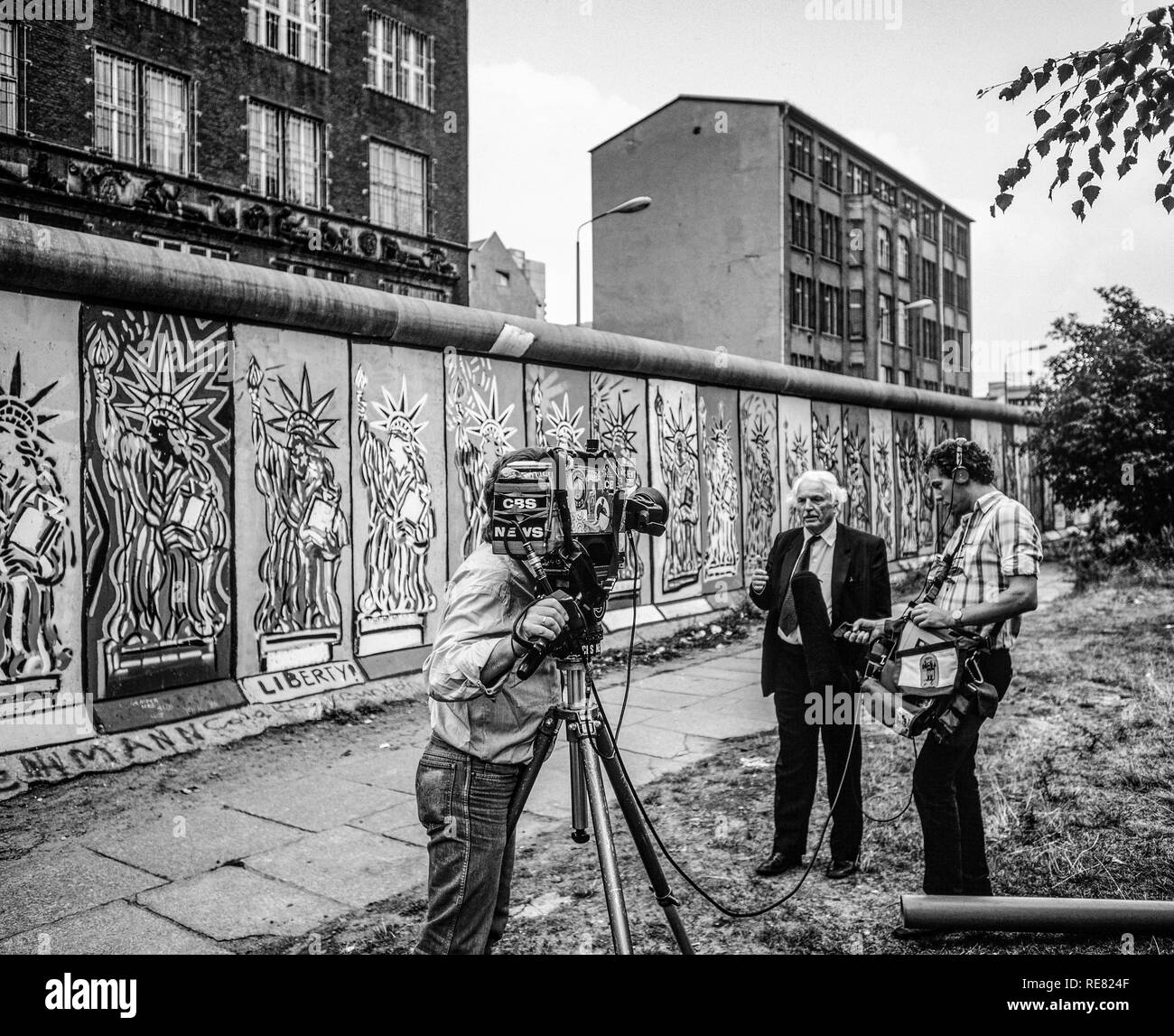 August 1986, CBS TV television crew conducting an interview in front of Berlin Wall decorated with Statue of Liberty frescos, West Berlin side, Germany, Europe, Stock Photo