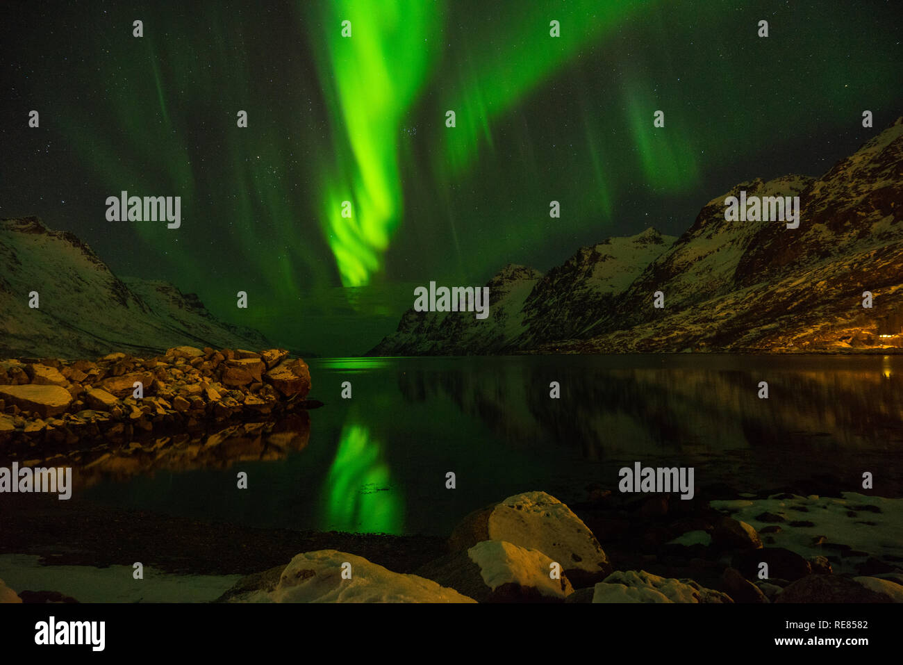 Green nordic lights, aurora borealis, at Erstfjordsbotn, Kvaloya, Tromso, Norway with mountains and a fjord Stock Photo