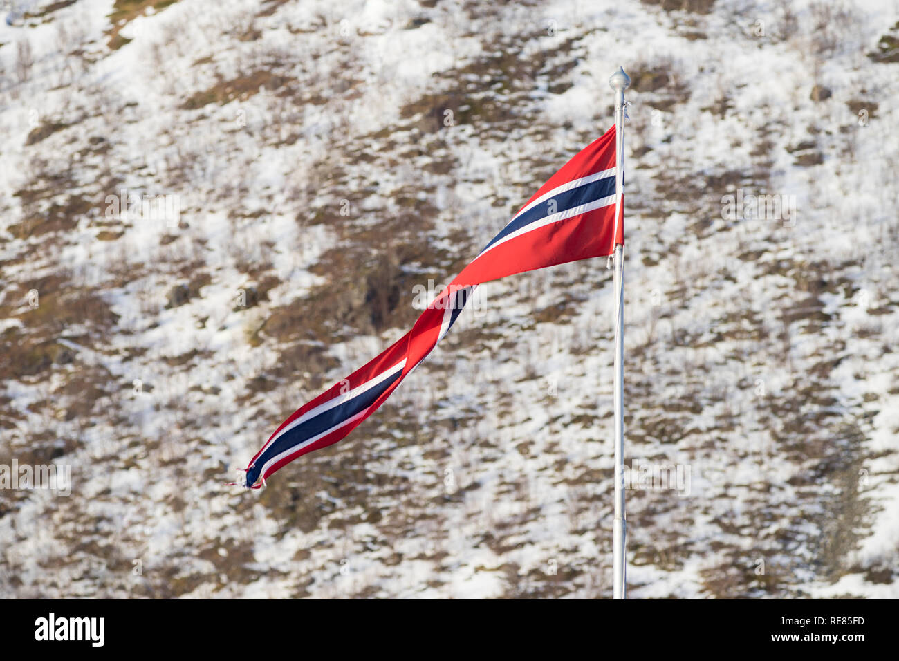 Norwegian banner on a flag pole in the arctic village of Rekvik, Kvalsoya Stock Photo