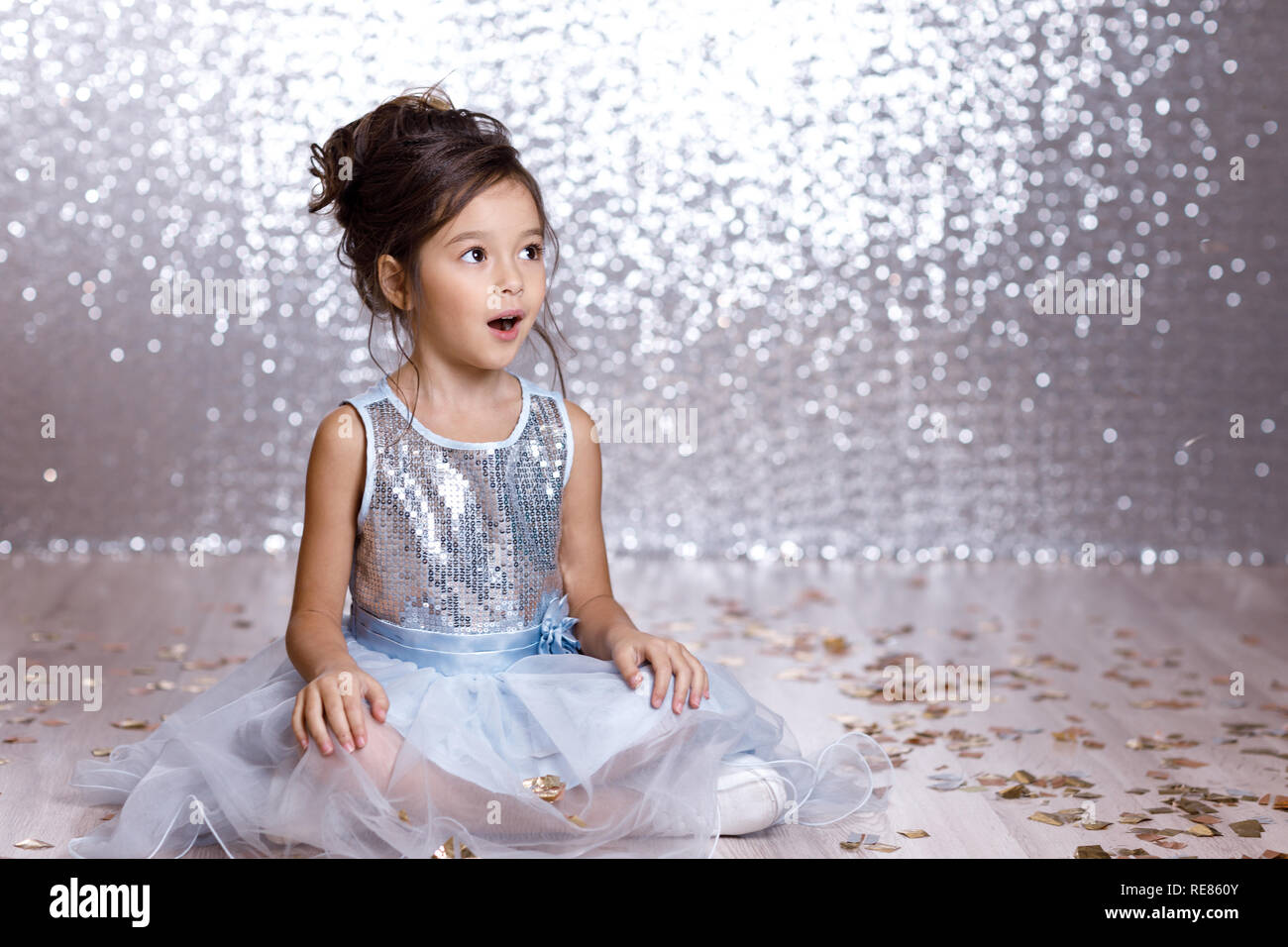 little girl in blue dress sitting on the floor with confetti Stock ...