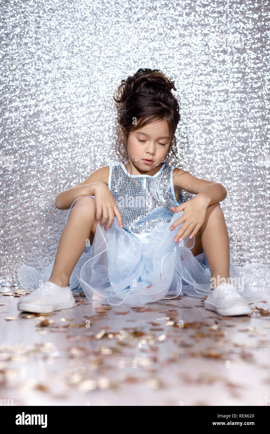 little child girl in dress sitting on the floor with confetti