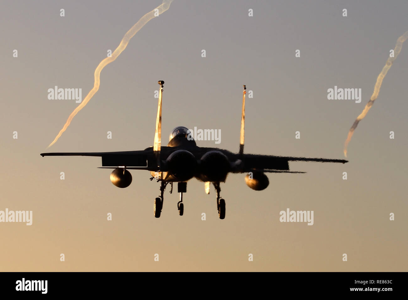 493rd Fighter Squadron F-15C landing at Lakenheath at dusk in sub-zero temperatures causing long wing tip vortices. Stock Photo