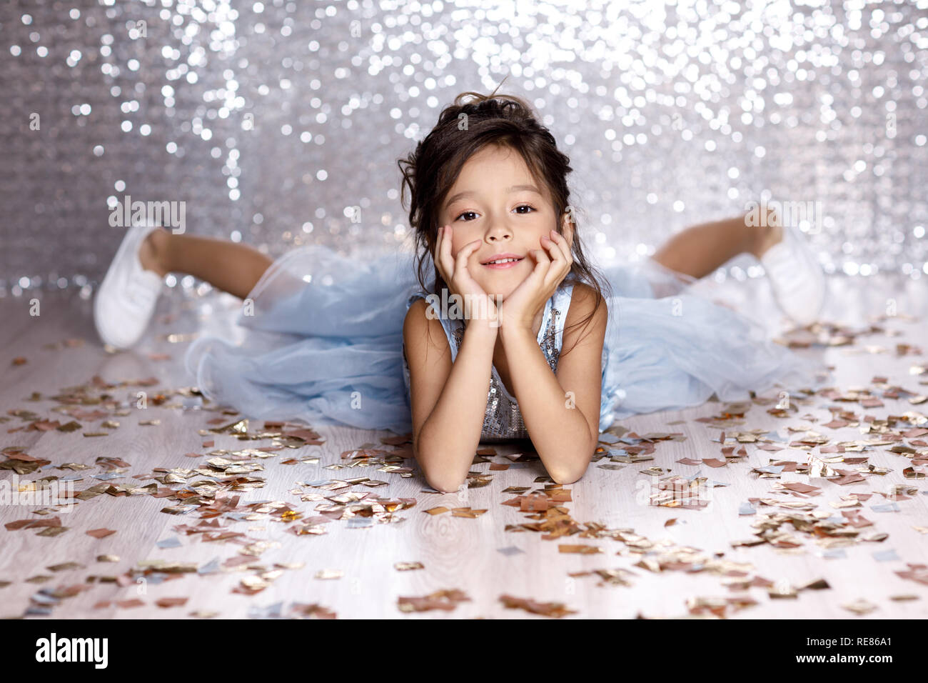 little girl in blue dress sitting on the floor with confetti Stock ...