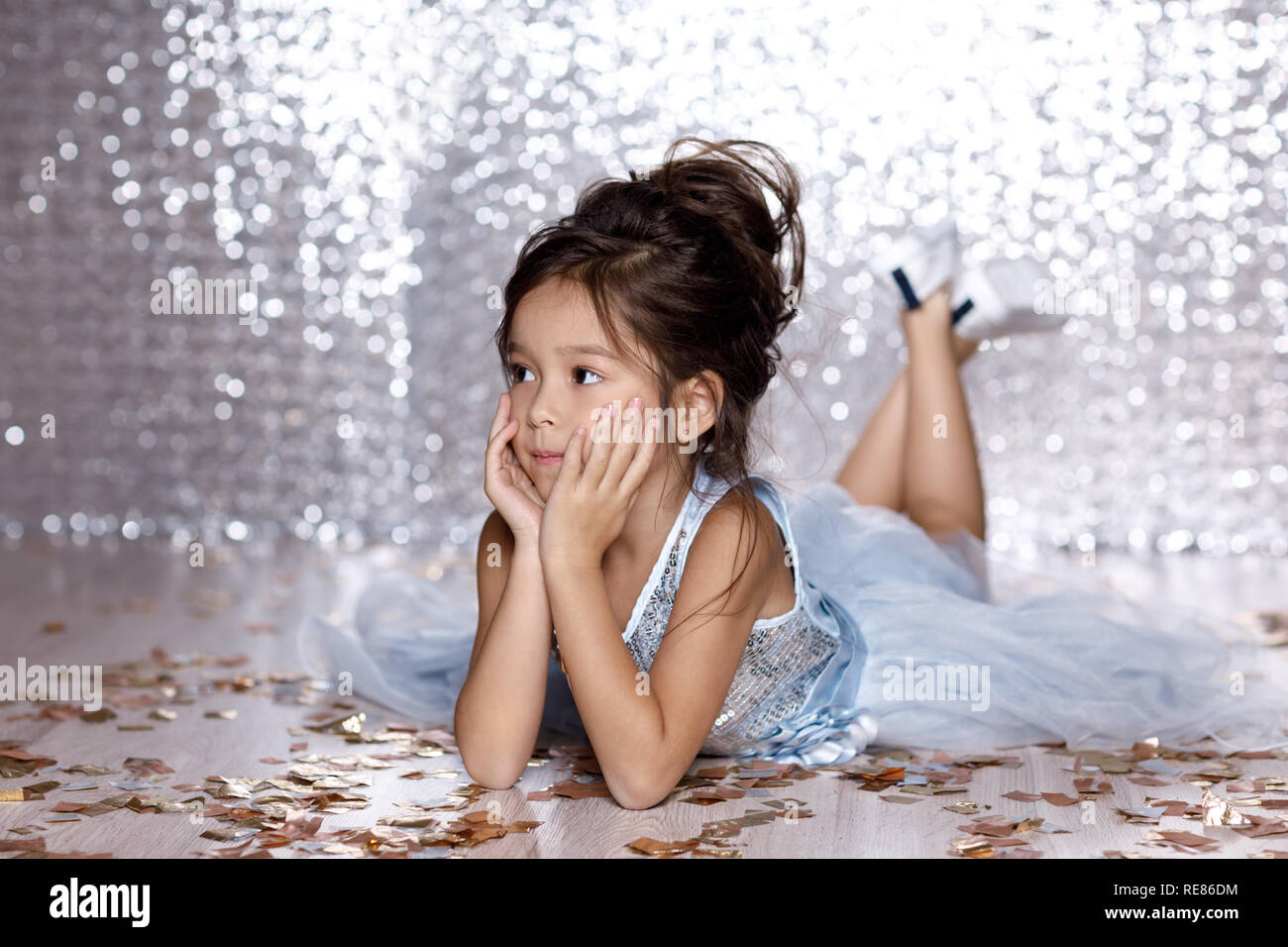 little girl in blue dress sitting on the floor with confetti Stock ...