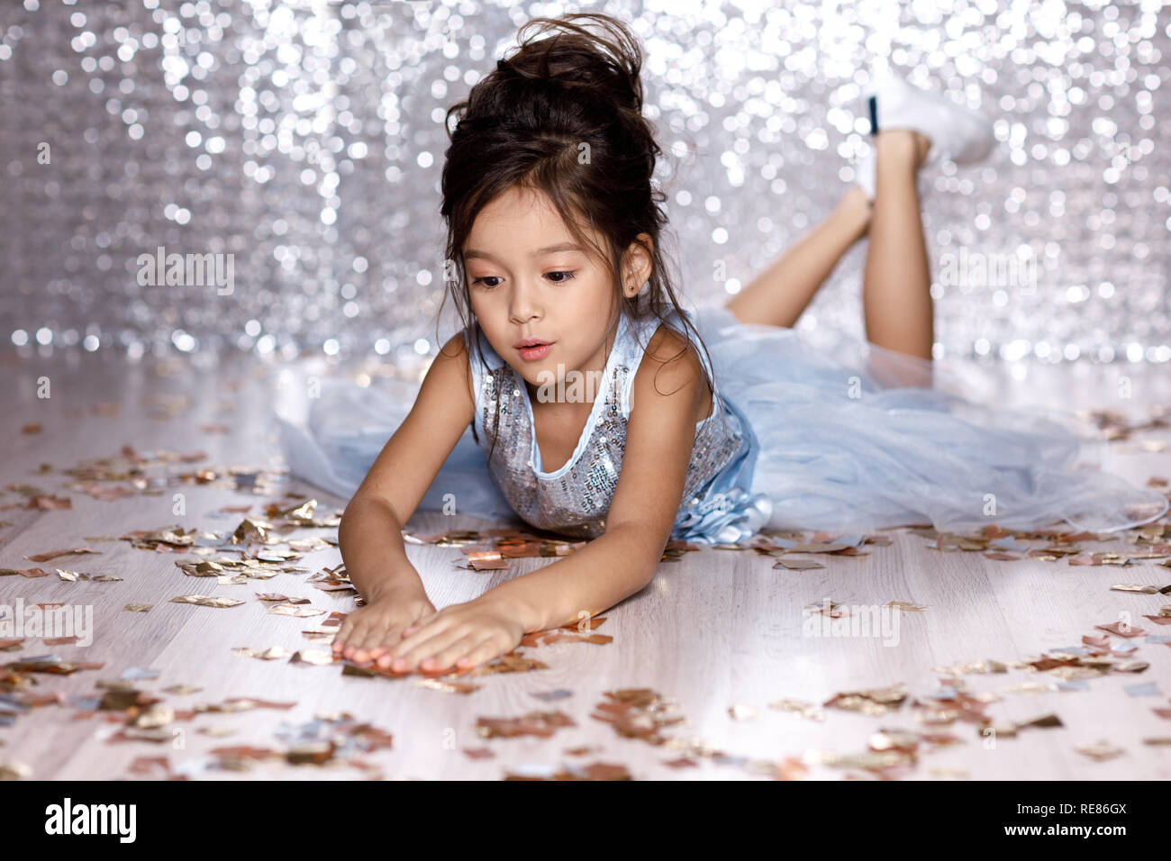 little girl in blue dress sitting on the floor with confetti Stock ...
