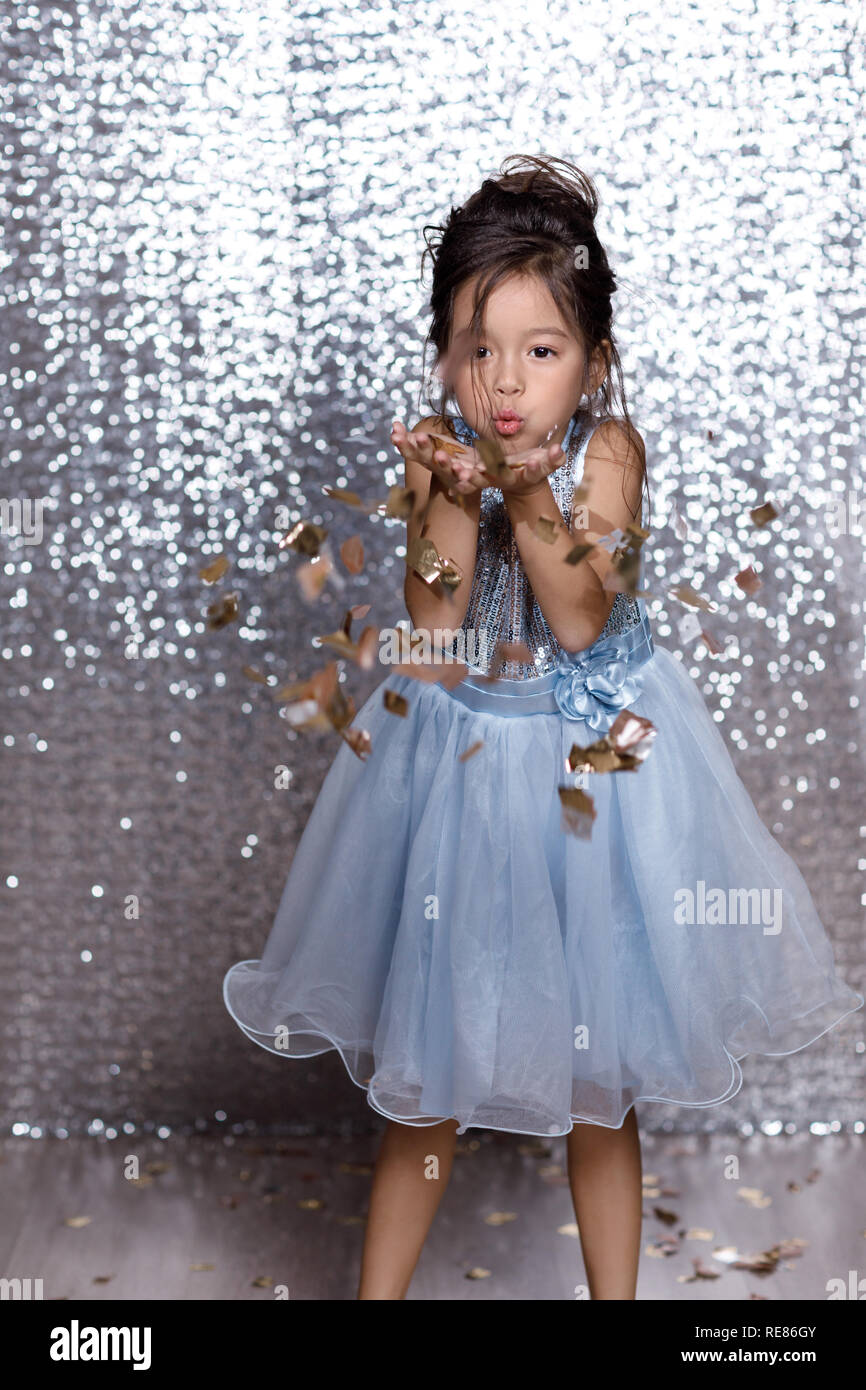 beautiful little child girl in silver and blue dress with confetti