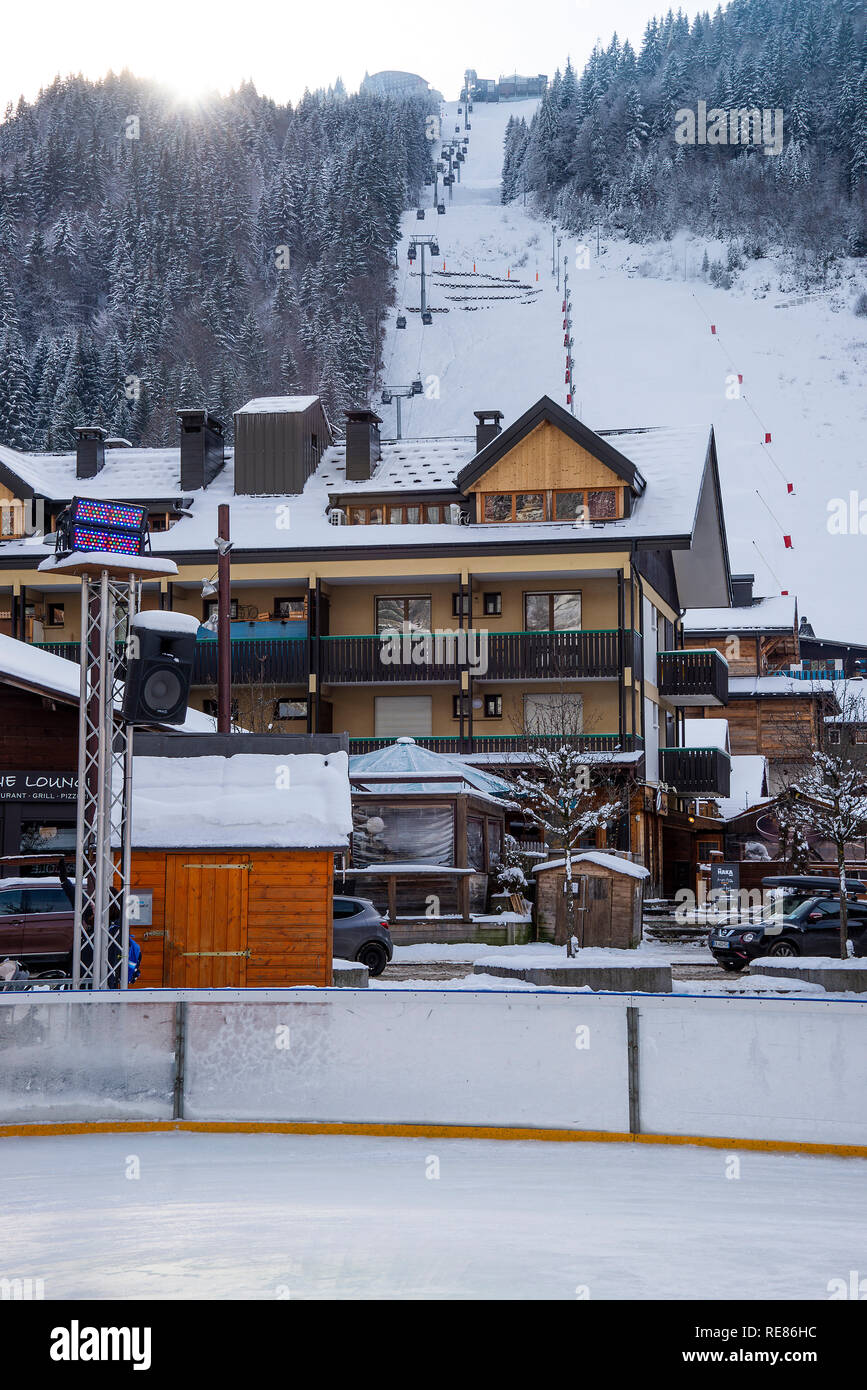 Colourful Shops and Restaurants with Ski Slopes Behind and Snow Covered Street in Morzine Haute