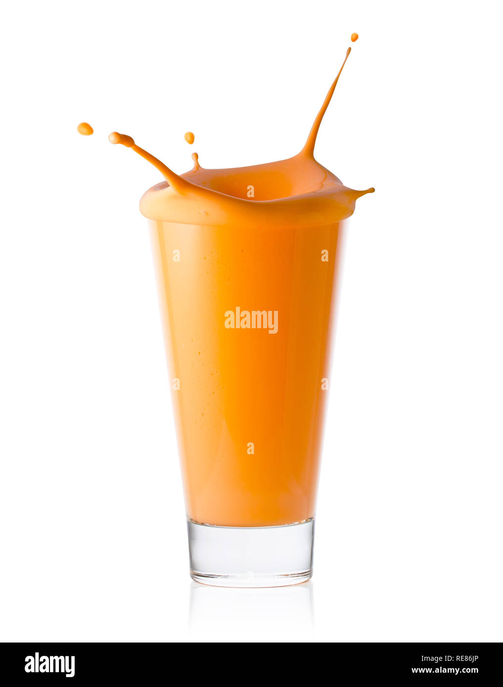 A glass of citrus or carrot smoothie or yogurt with a splash isolated