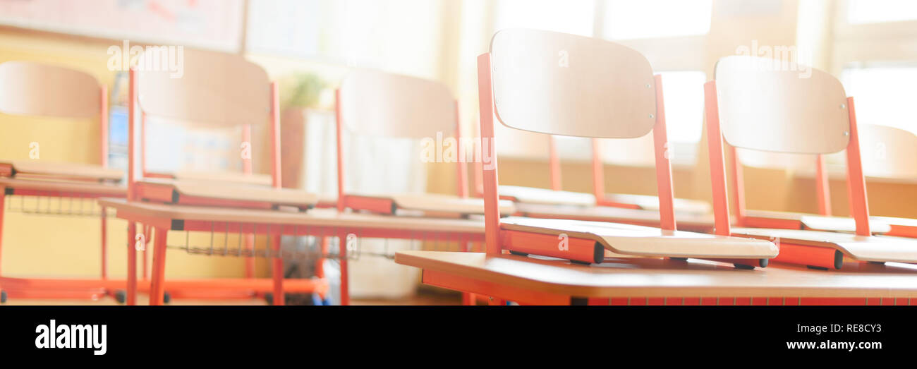 Empty classroom with school desks, chairs and blackboard. Education concept. Stock Photo