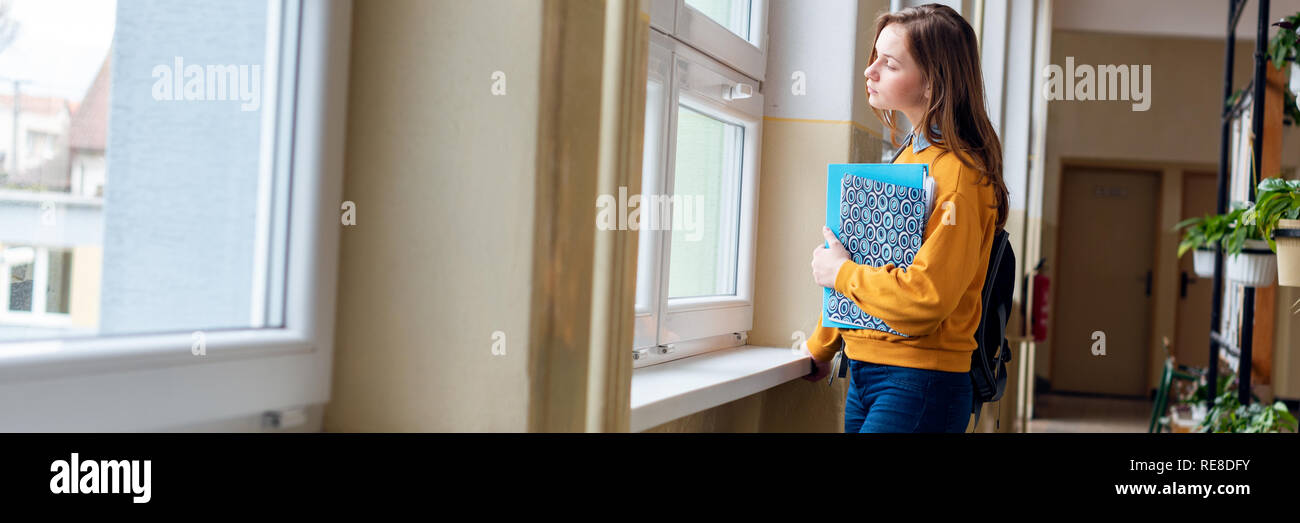 Window Alone Student Young attractive female high school student standing by the window in ...
