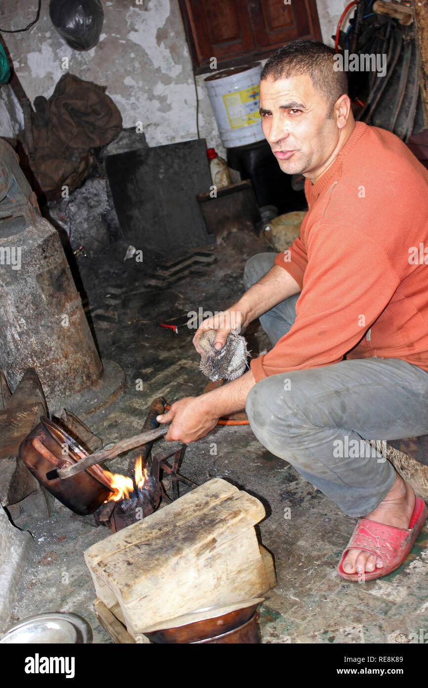 Metalworker in his workshop at the Place el Seffarine, Medina of Fes el Bali, Fez, Morocco Stock Photo