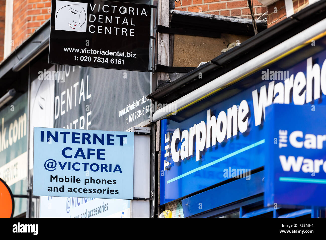 London, UK - June 21, 2018: Neighborhood district of Victoria closeup of signs for Internet Cafe, Dental Care and phone warehouse stores, shops Stock Photo