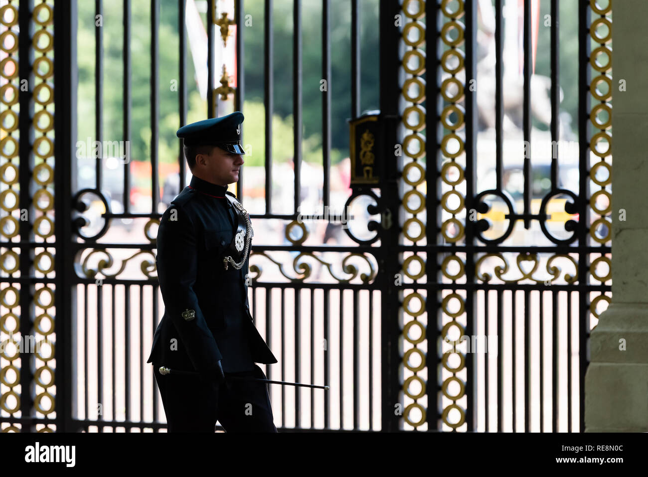 London, UK - June 21, 2018: One English Royal security guard police officer walking marching in front of Buckingham Palace gate fence in Green Park Stock Photo