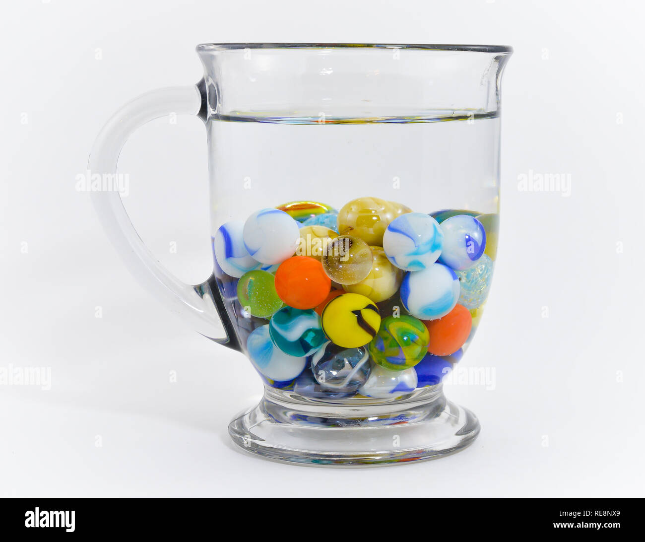Mug full of marbles in water Stock Photo Alamy