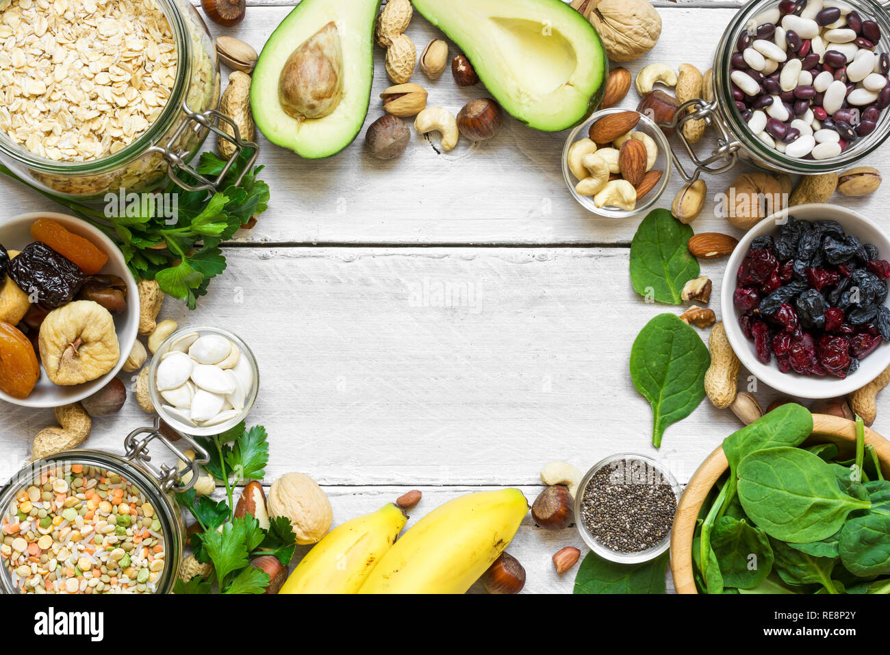 Potassium Food Sources as dried apricots, raisins, avocado, bean, pumpkin and chia seeds, banana, nuts, spinach, almonds. top view with copy space. fl Stock Photo