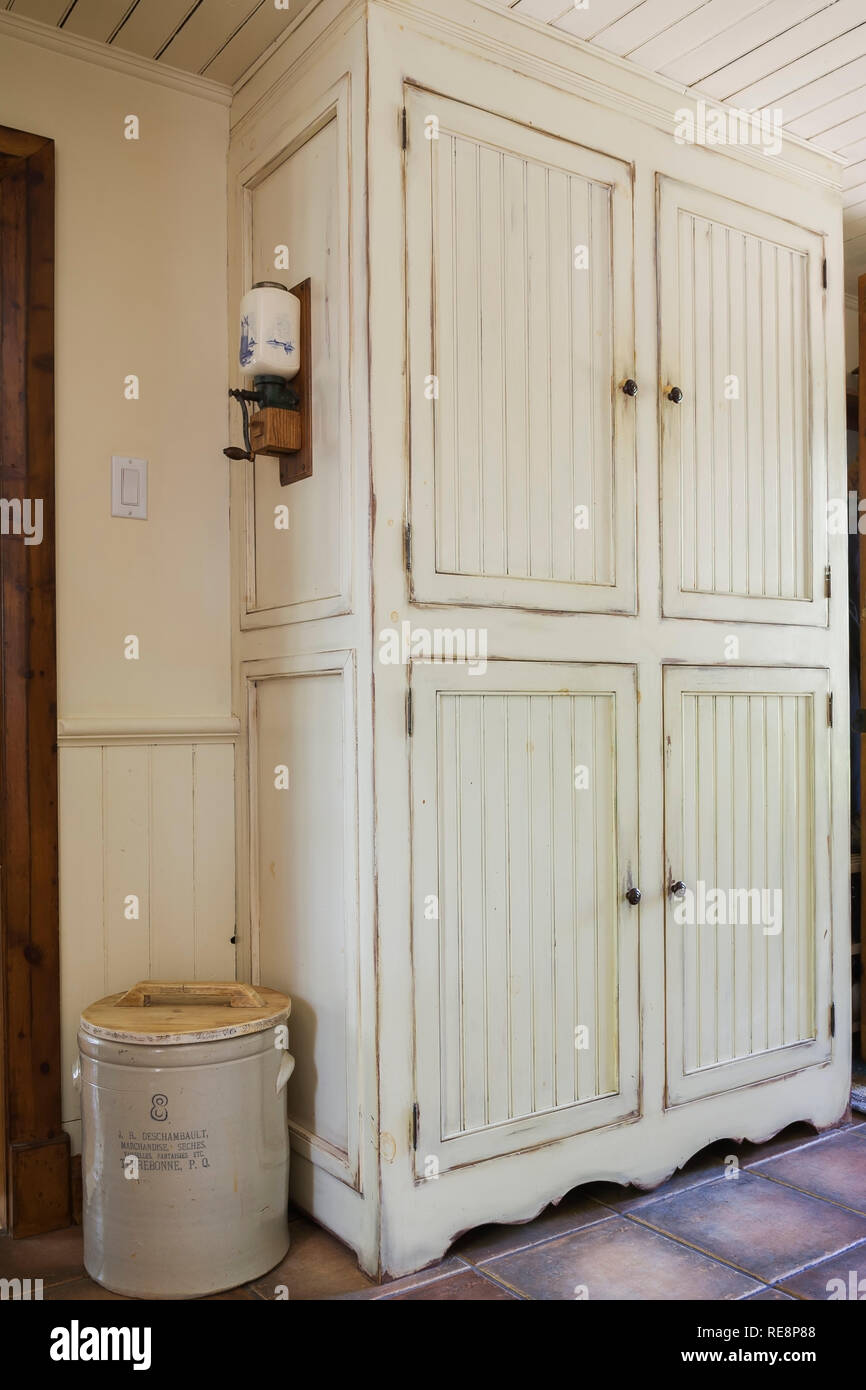Floor to ceiling cream coloured antique finish wooden armoire in